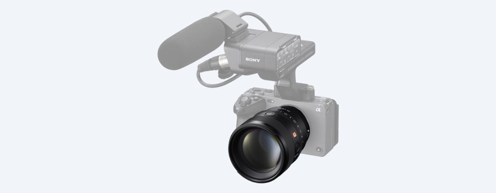 A product image showing the lens mounted on the desaturated FX3 with a desaturated microphone attached